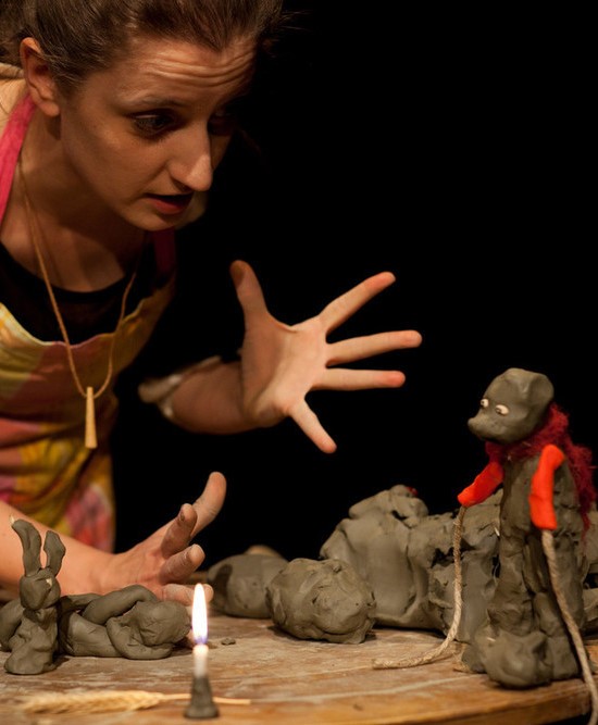 Attrice in scena con un pupazzo in argilla