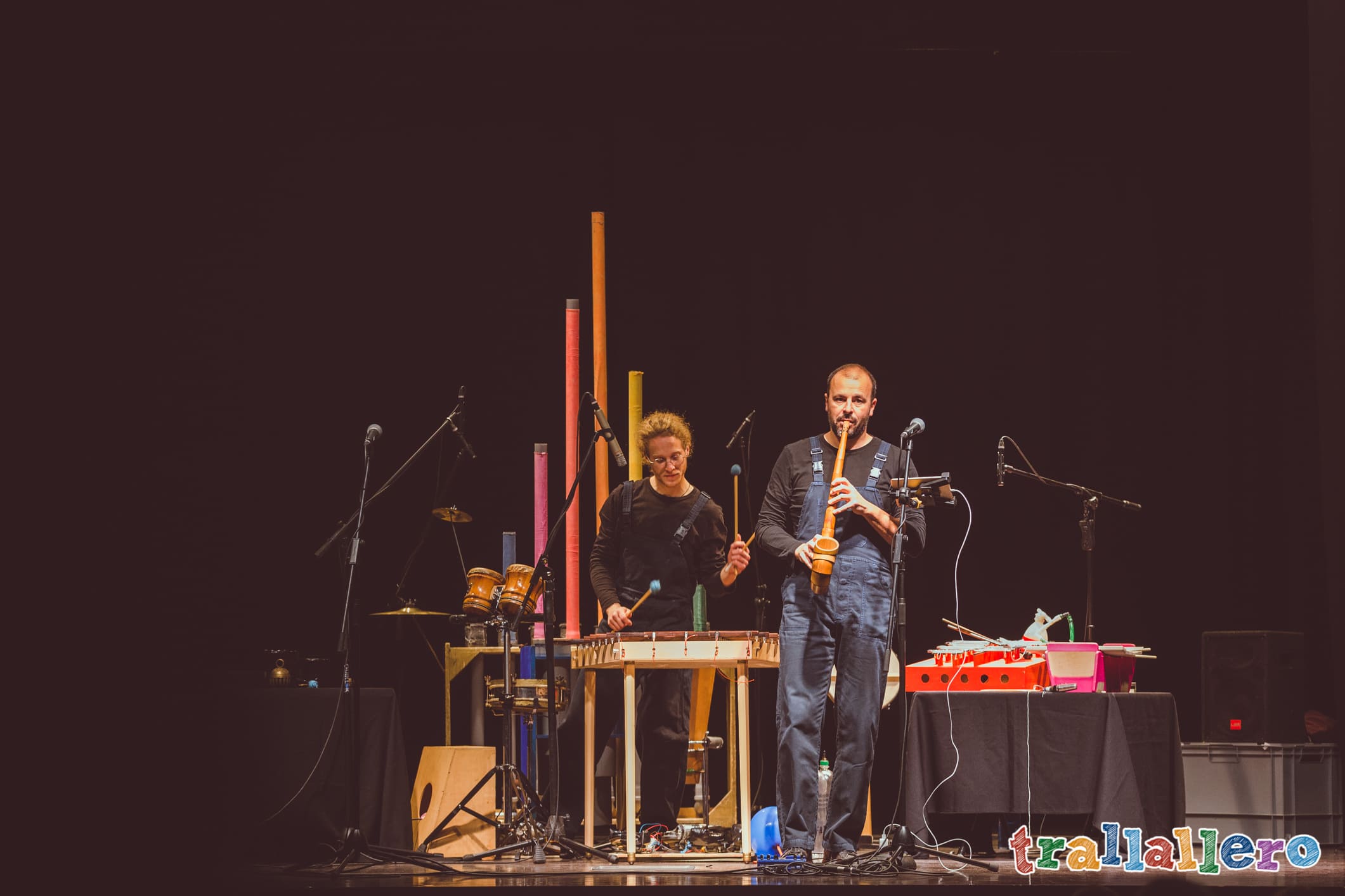 attori in scena che suonano strumenti musicali inventati