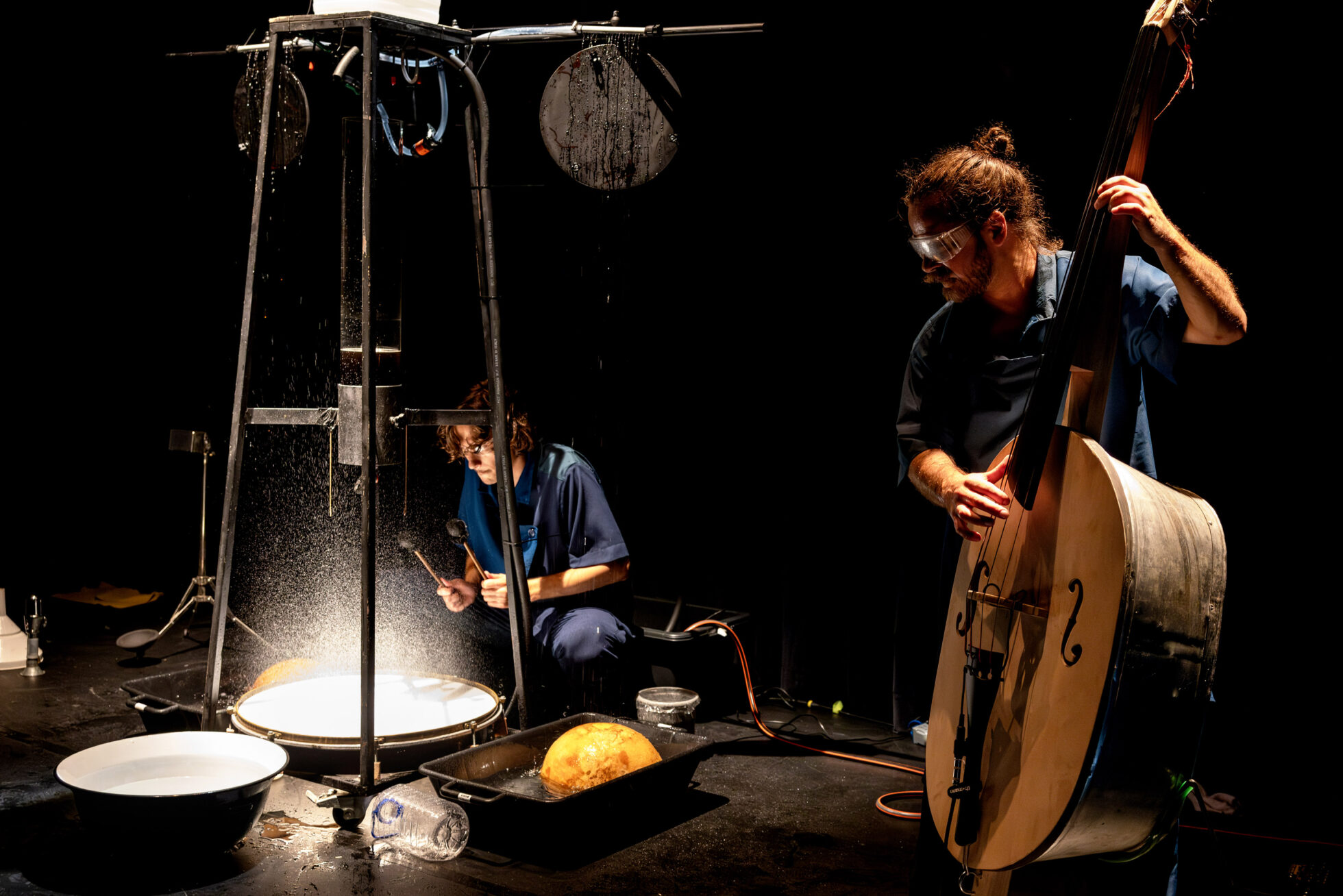 Attori in scena che suona strumenti musicali inventati