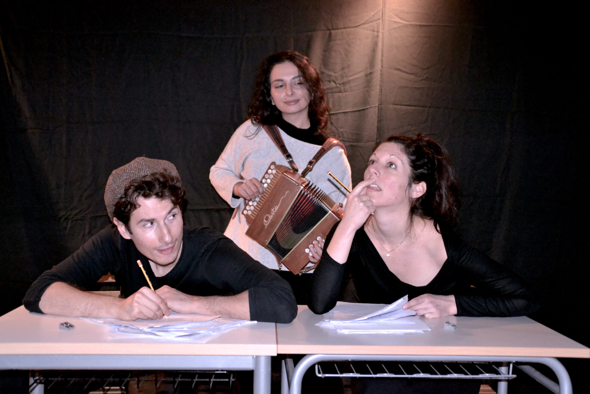 tre attori in scena, uno di loro con l'organetto